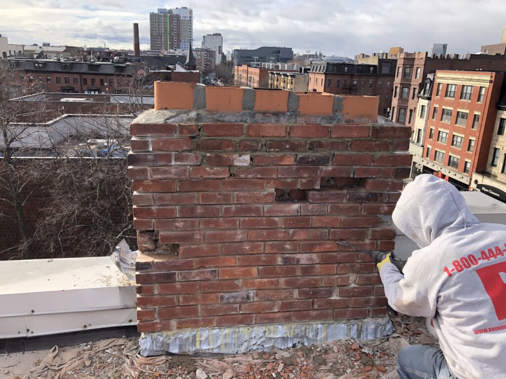 Contractor working on chimney repair in Boston, MA.
