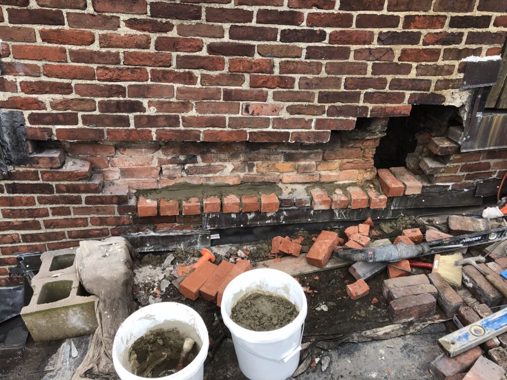 Chimney under repair with several missing bricks.
