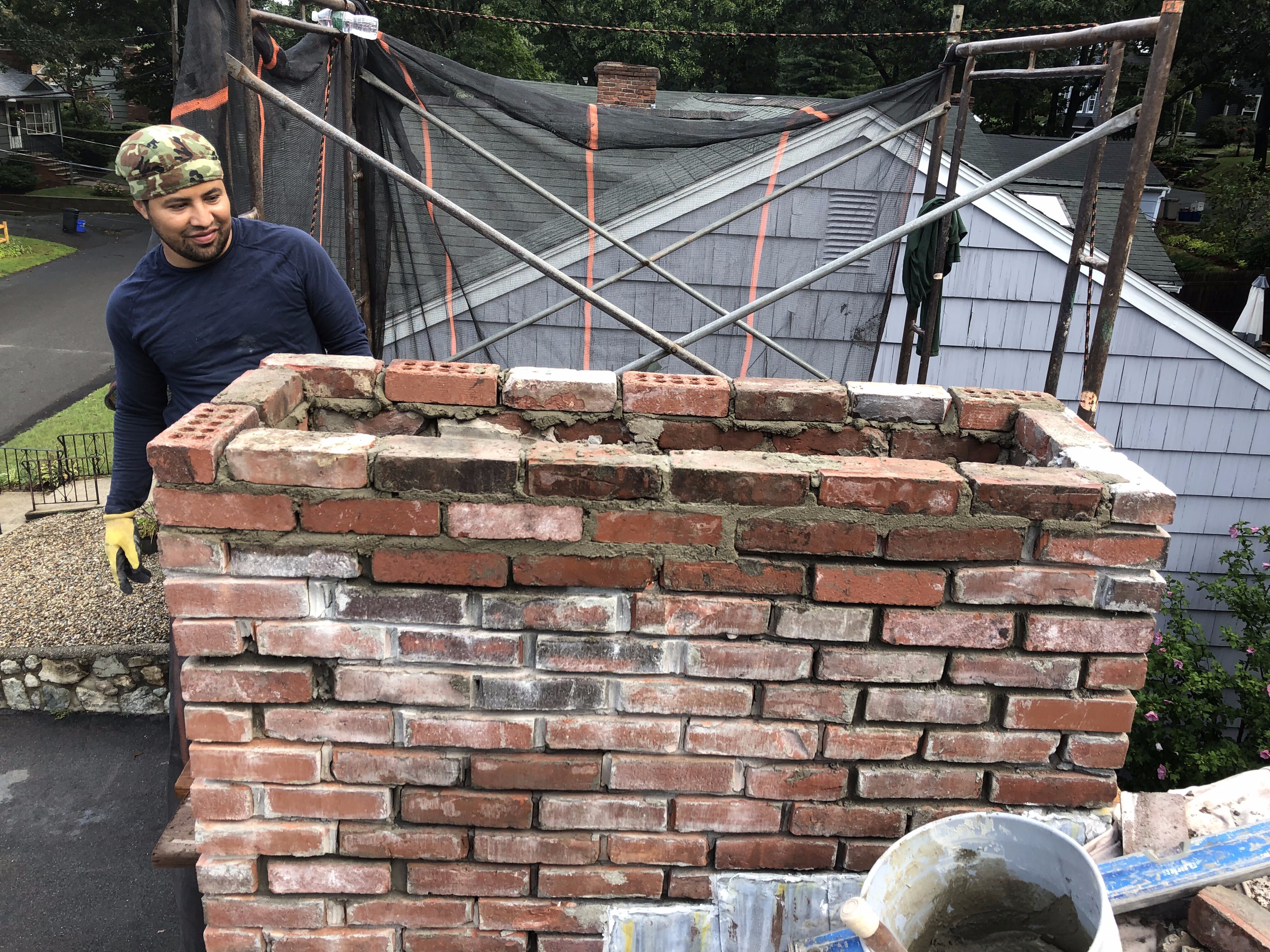 Contractor working on chimney repair in Cambridge, MA.
