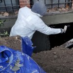 Contractor applying waterproofing material to a basement in Boston, MA.