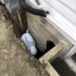 Contractor applying waterproofing material to a basement in Boston, MA.