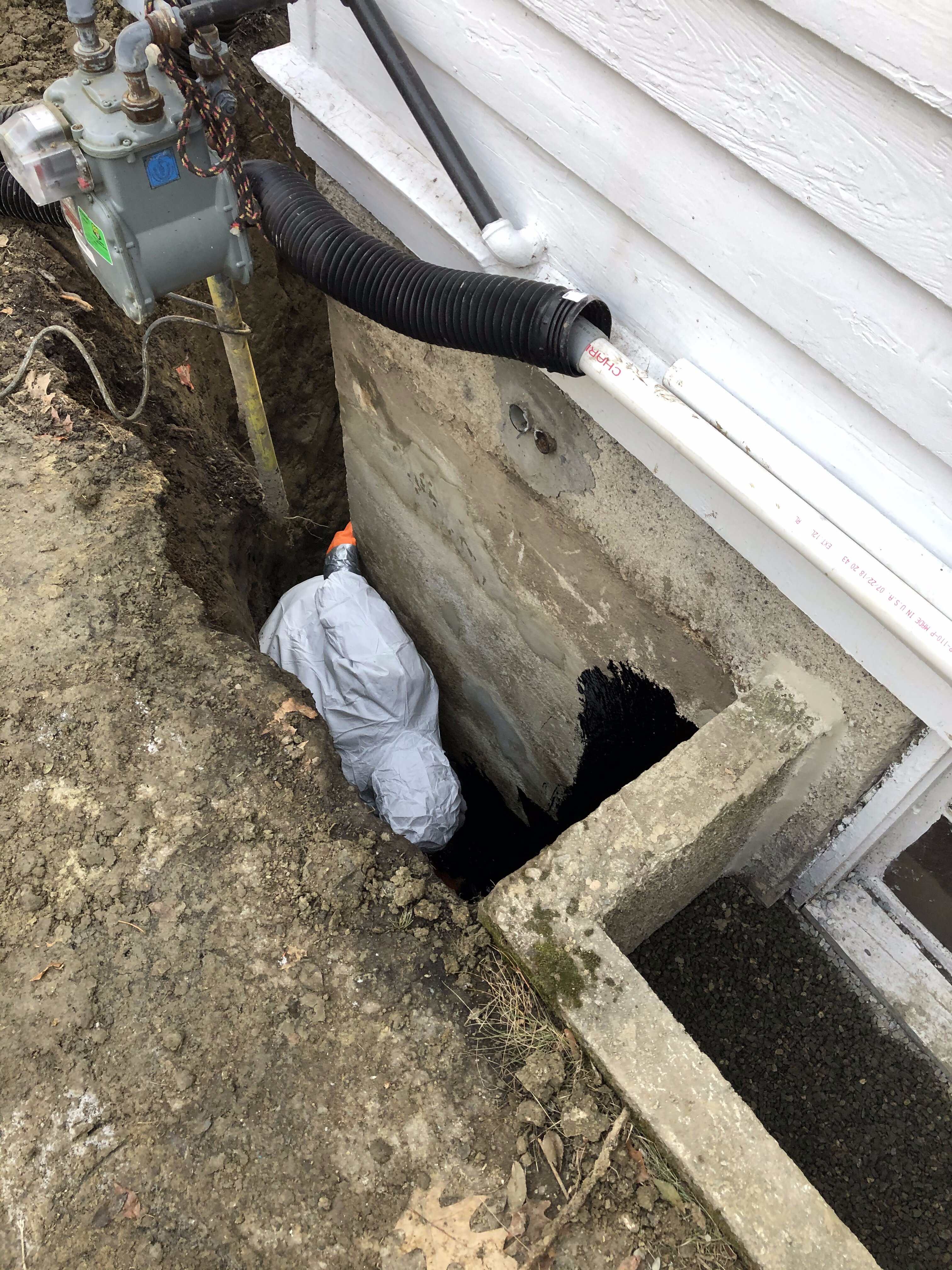 Contractor applying waterproofing material to a basement in Boston, MA.