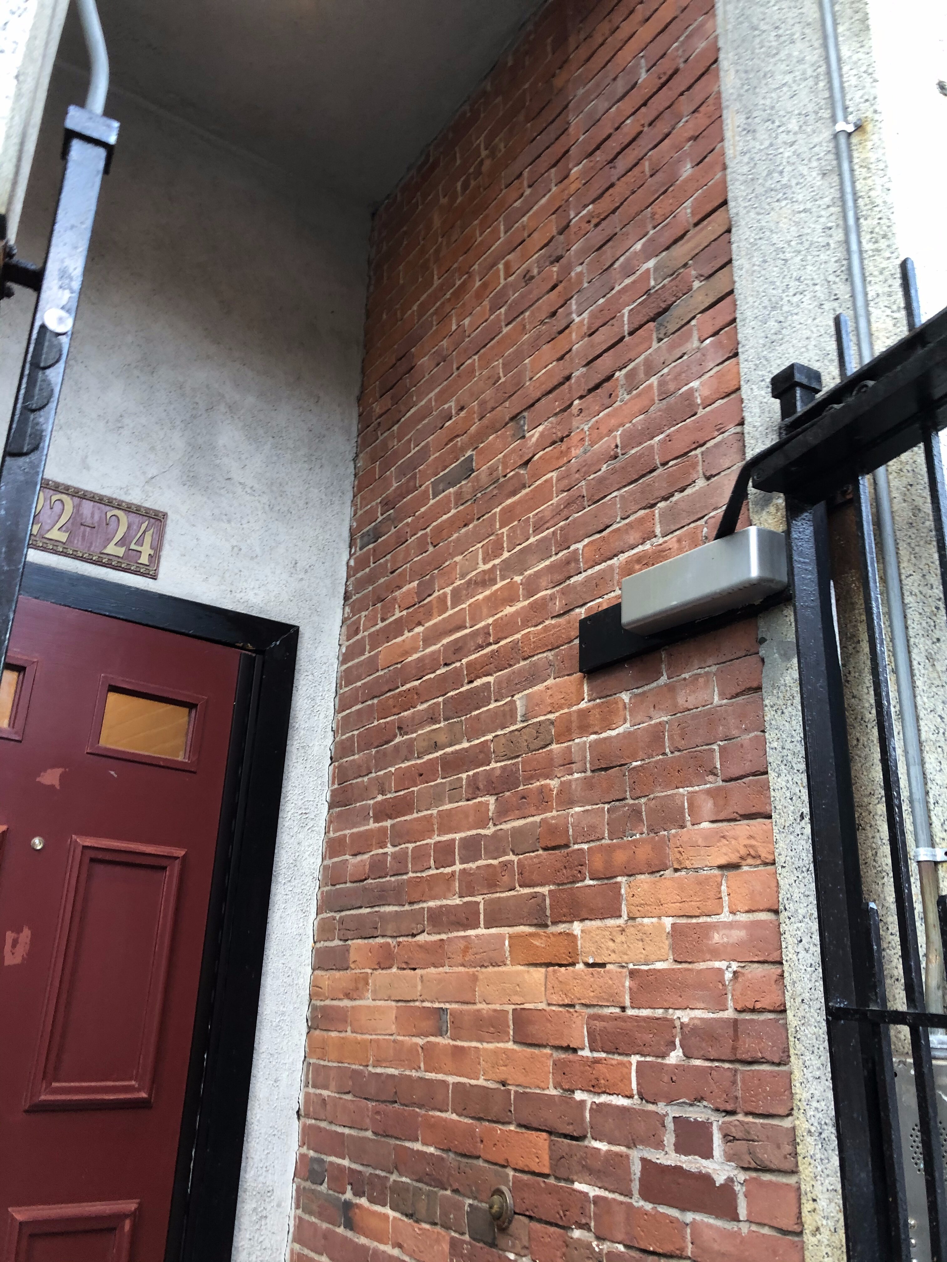 Newly waterproofed brick wall outside of an apartment door in Cambridge, MA.