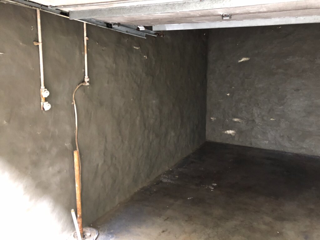 Basement interior with waterproofing material applied to the walls to prevent moisture intrusion.