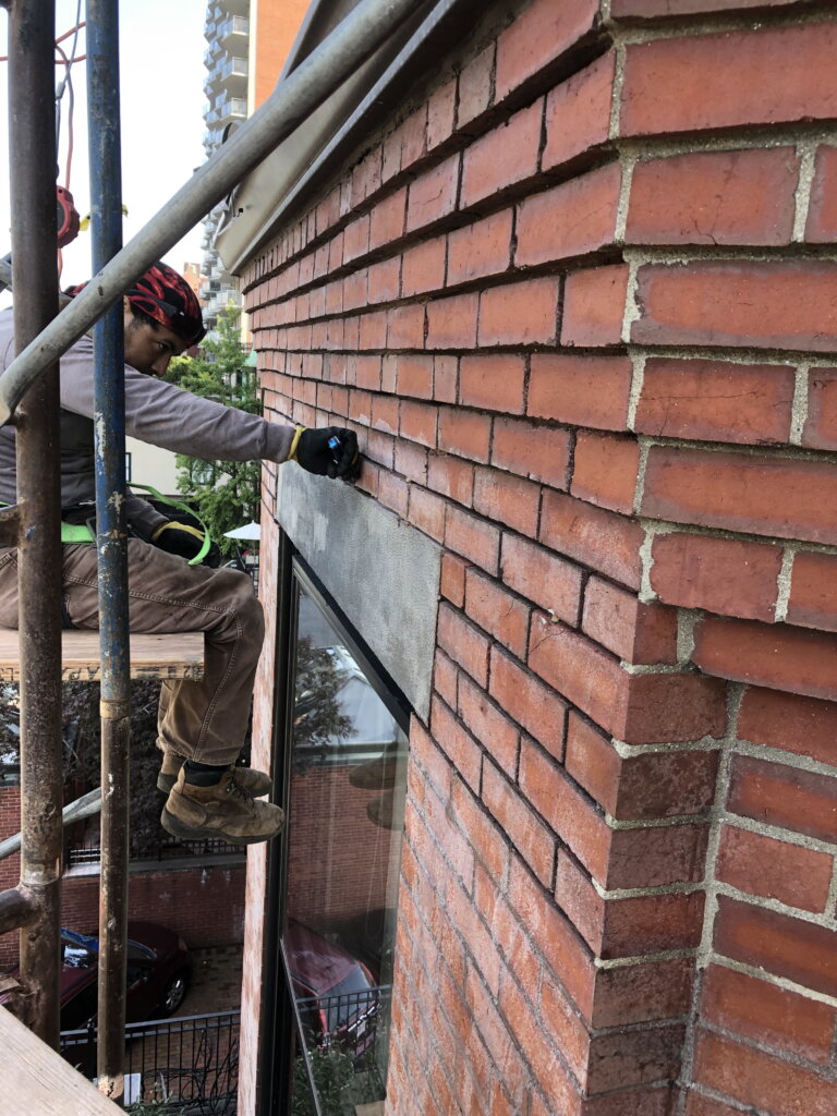 Contractor working on brick restoration in Boston, MA.