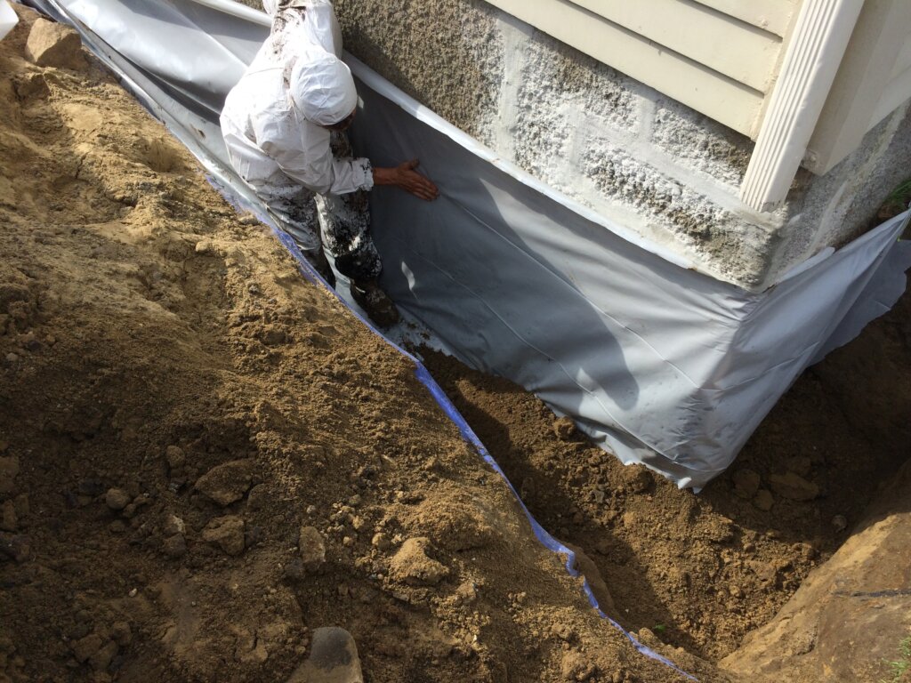 Contractor getting ready to waterproof a basement in Boston, MA.