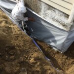 Contractor getting ready to waterproof a basement in Boston, MA.