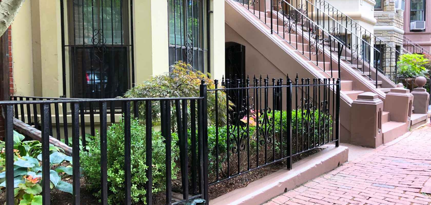 Row of houses in downtown Boston, MA with a well-maintained brick walkway in front.