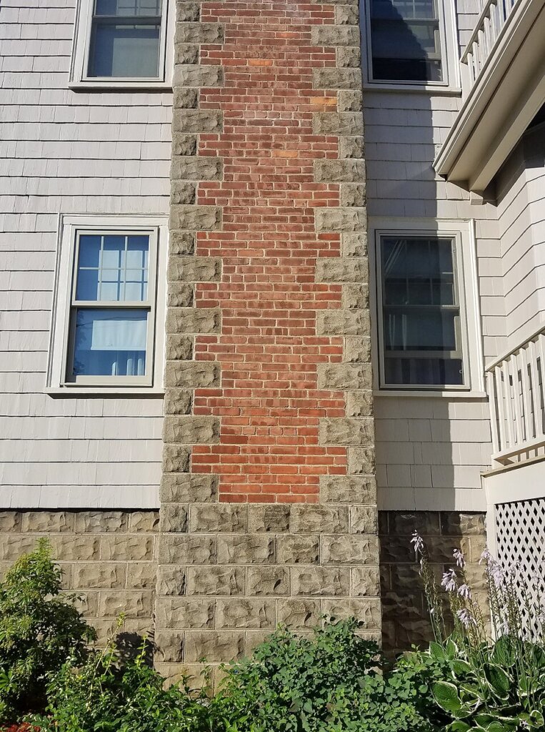 Brick and stone chimney on a residential house in Arlington, MA.