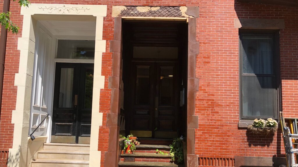 Historic brick building entrance with restored masonry, stone trim, and repointed brickwork in Boston
