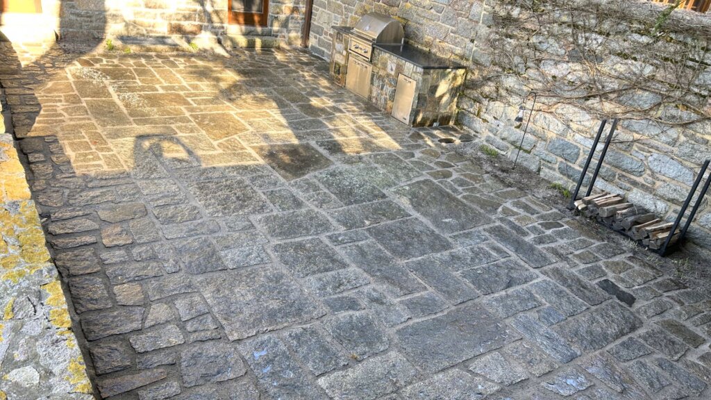 Custom stone patio and outdoor kitchen built with natural granite in Boston, MA