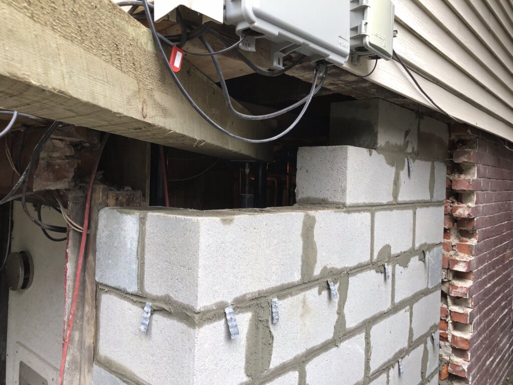 Reconstructed concrete block foundation wall during a structural repair project