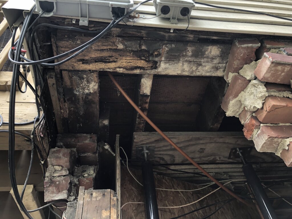 Foundation repair project showing water-damaged framing and deteriorated structural supports during demolition