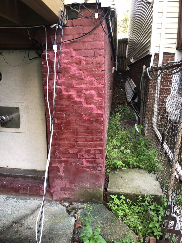 Stair-step crack in a brick foundation wall before foundation repair
