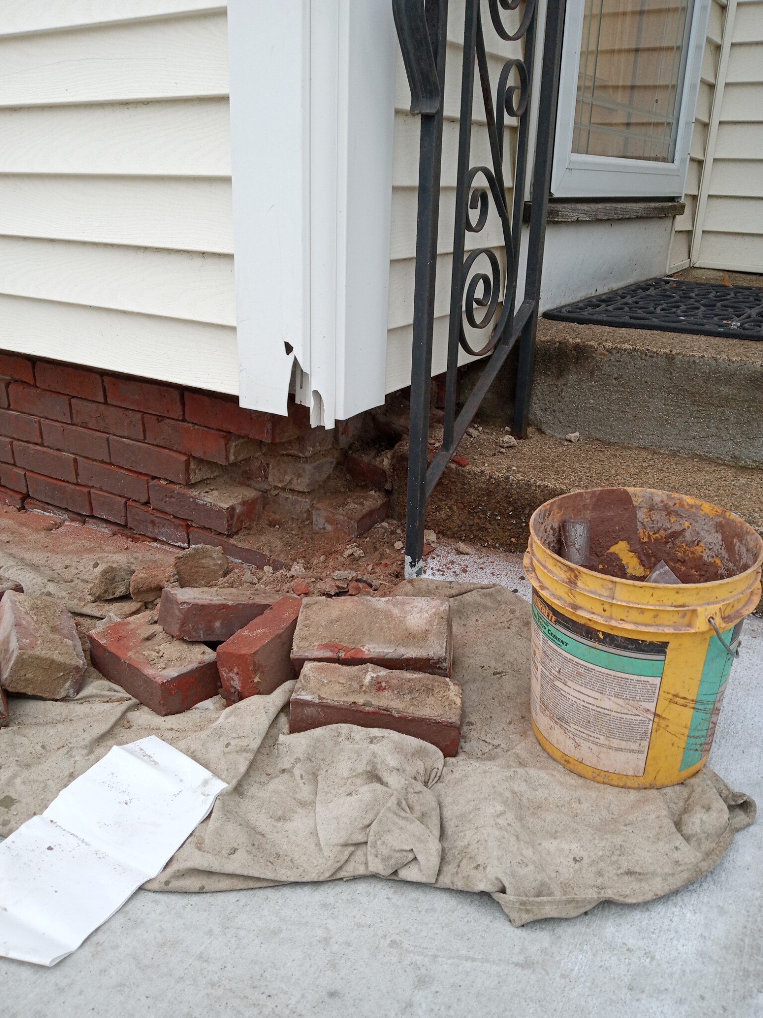 Repairing deteriorated brickwork beneath a front porch to restore structural support