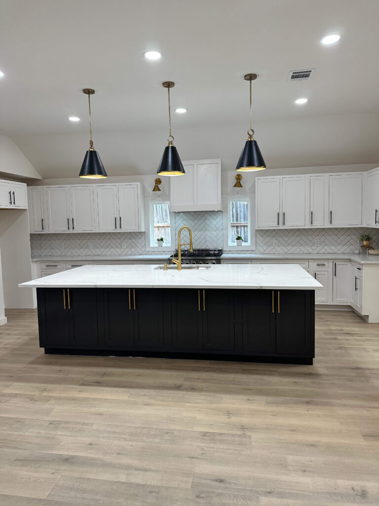 black kitchen island with white shaker cabinets and quartz countertops