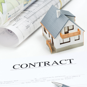 Model house sitting on a signed purchase contract
