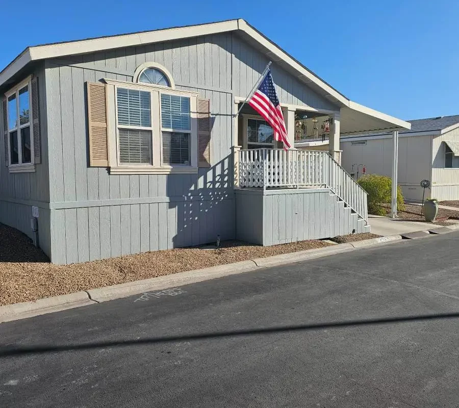 Double-wide mobile home with porch and American flag in a Tucson Arizona mobile home park