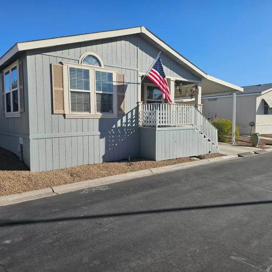 Double-wide mobile home with porch and American flag in a Tucson Arizona mobile home park