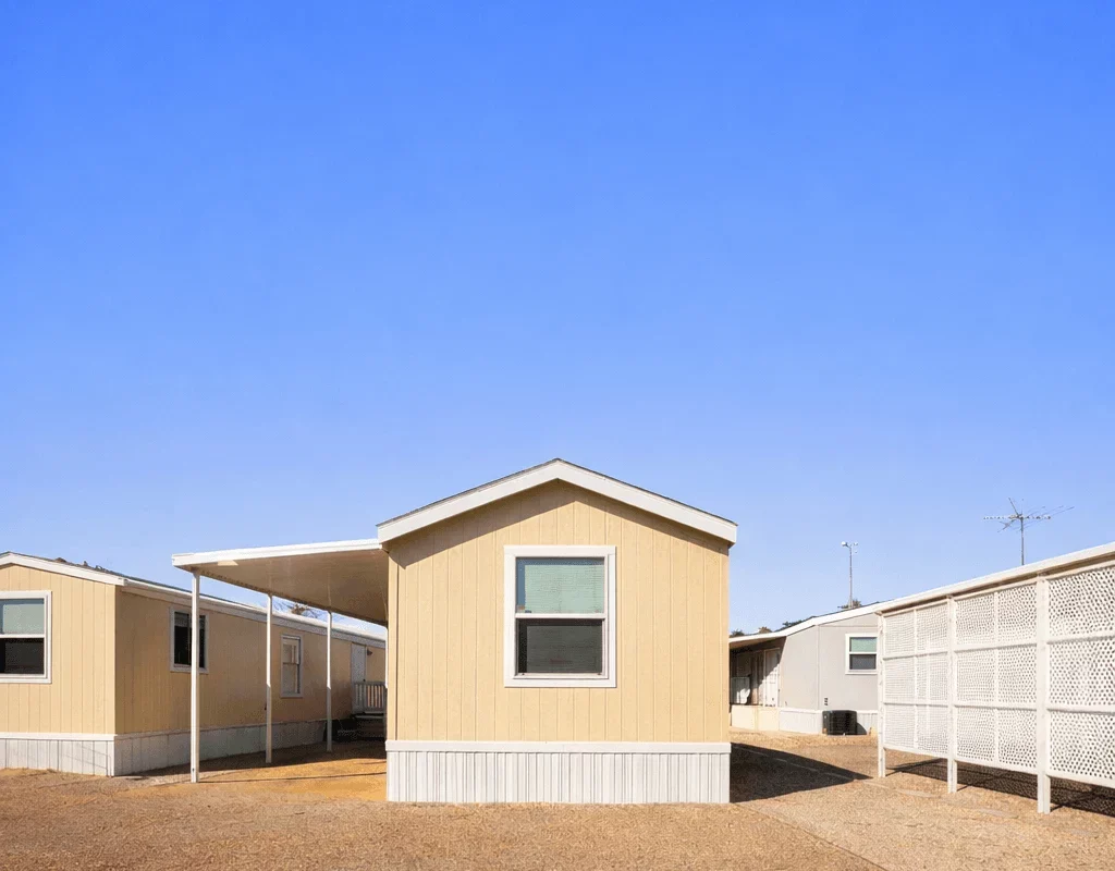Single-wide mobile home in a Tucson Arizona mobile home park with gravel yard and carport