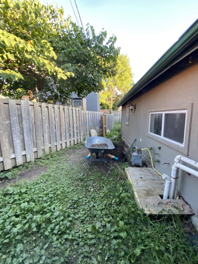 Real Cambridge, Ontario property we purchased as-is, showing the home’s side yard, fencing, and utility area.