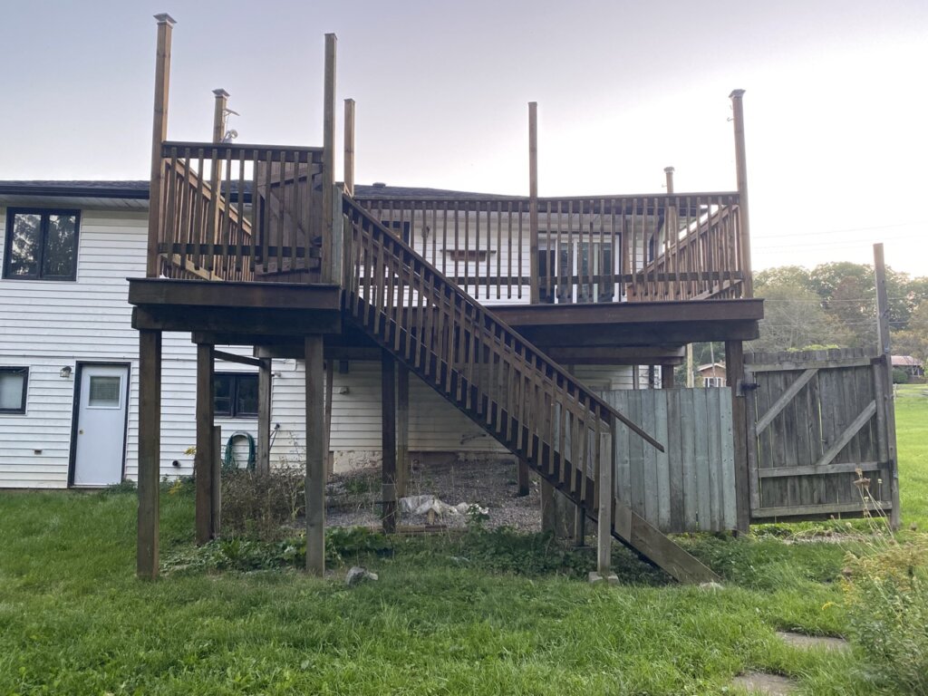 Real Brantford, Ontario property we purchased as-is, showing the elevated deck, stairs, and backyard area.