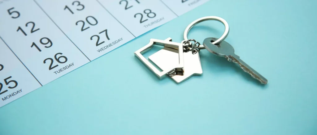 Homeowner reviewing a moving calendar beside packed boxes and house keys.