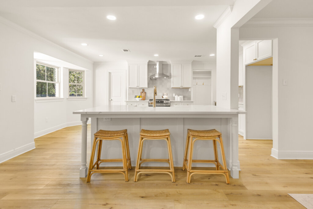 Kitchen renovation in Mandeville LA with open layout, custom island, hardwood floors, and modern lighting