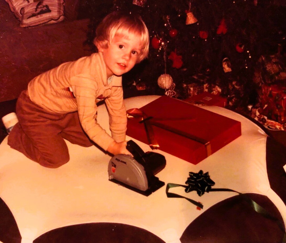 Ryan Cartier as a child at Christmas, already drawn to tools and building