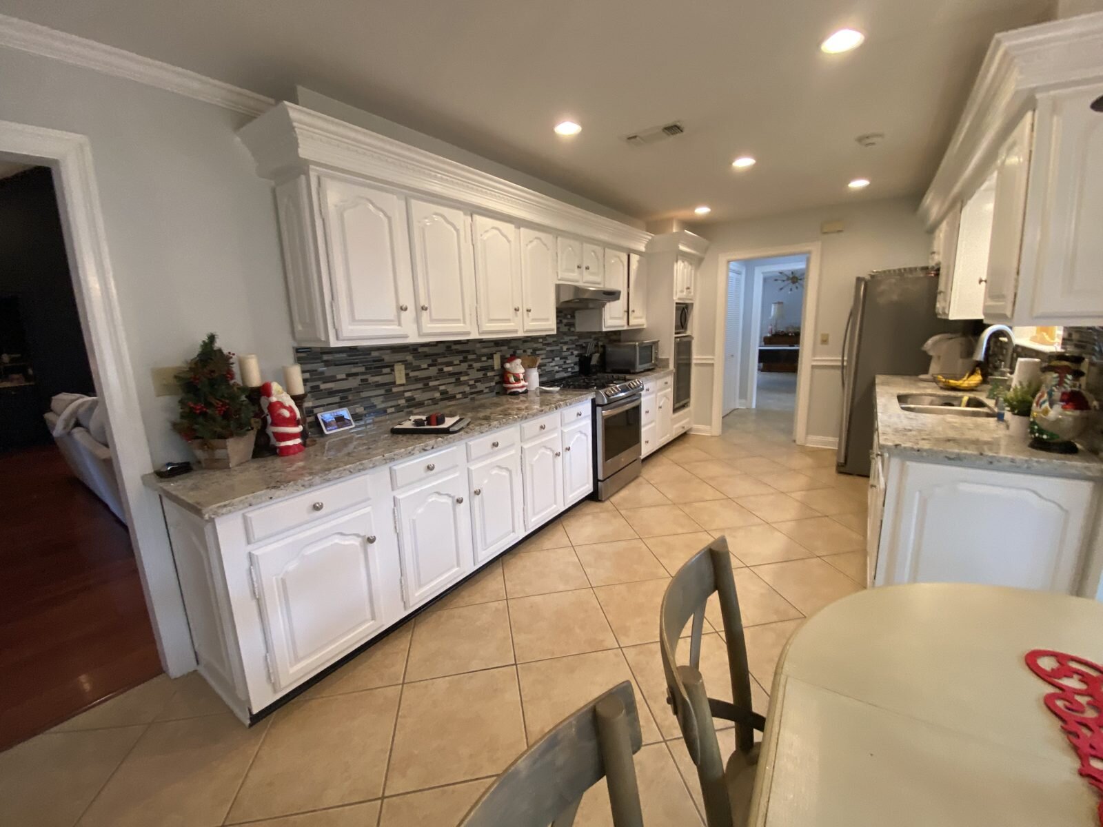 Beau Chêne kitchen before renovation with white cabinets and tile floor, Mandeville, LA