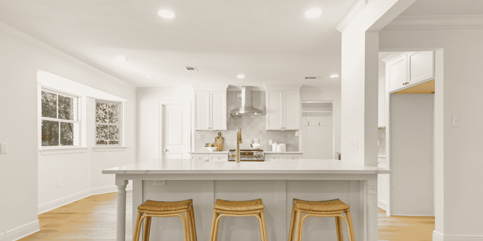 Bright modern kitchen with white cabinets, center island, and bar seating in a Mandeville Louisiana home