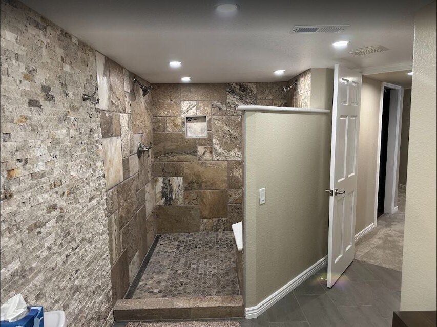 Completed walk-in shower renovation with tiled walls and glass enclosure