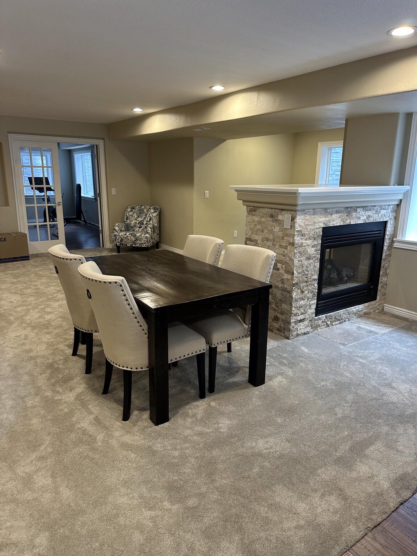 Basement dining nook near a stone fireplace, completed remodel by The Build Squad