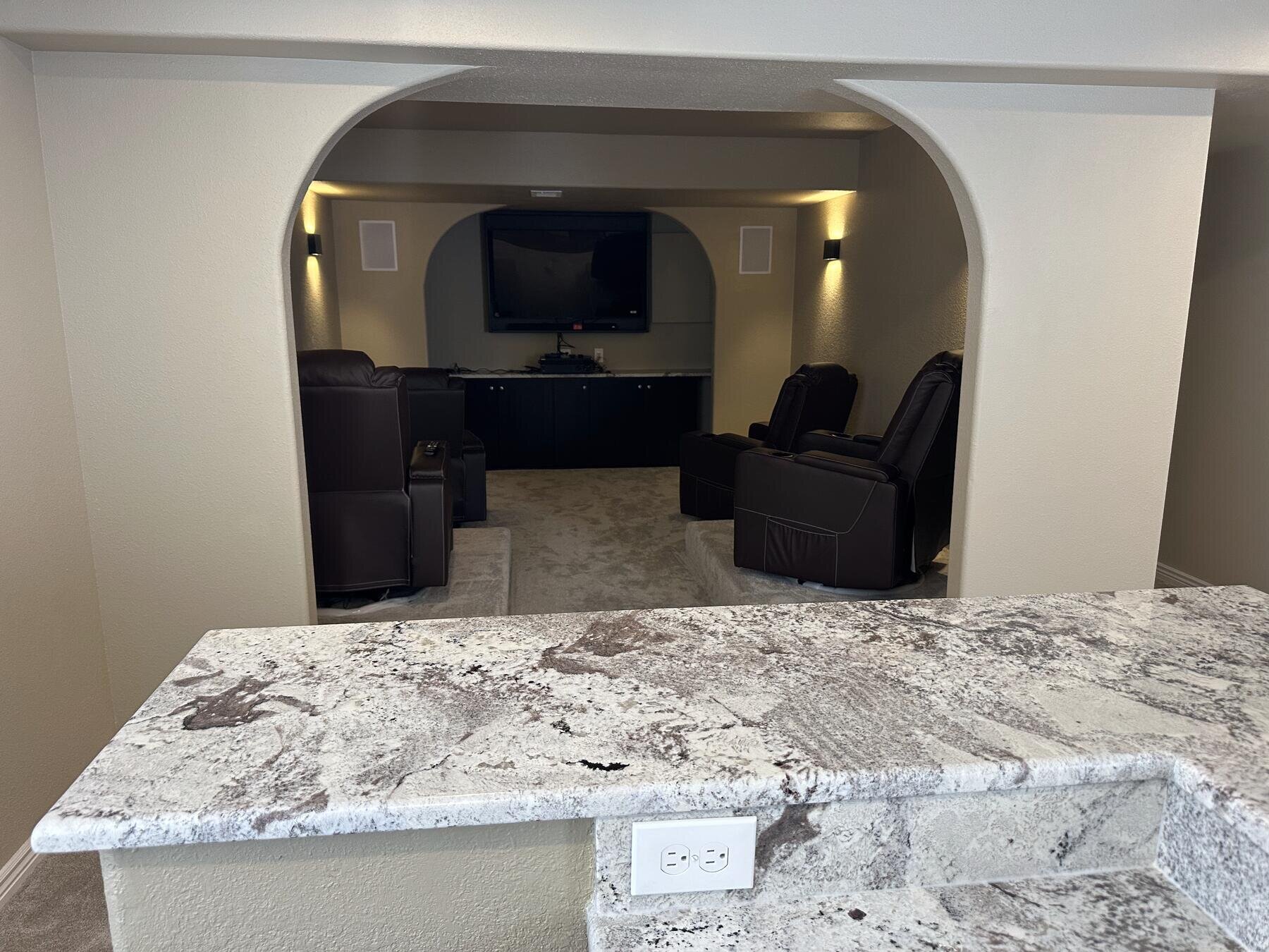 Finished basement home theater seating area, completed remodel by The Build Squad