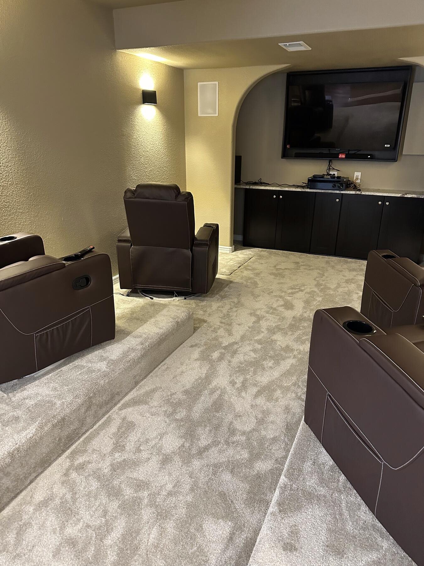 View of a finished basement home theater from the adjoining wet bar, completed remodel by The Build Squad