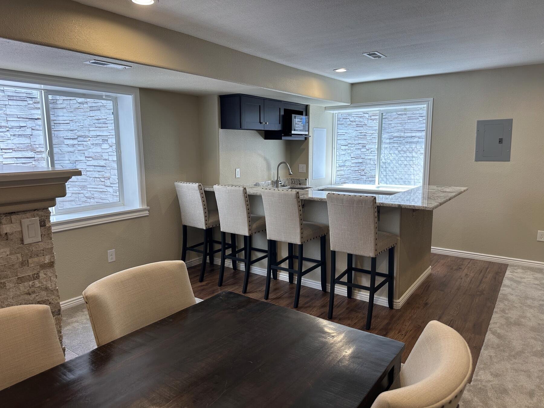 Finished basement wet bar and kitchenette with island seating, completed remodel by The Build Squad