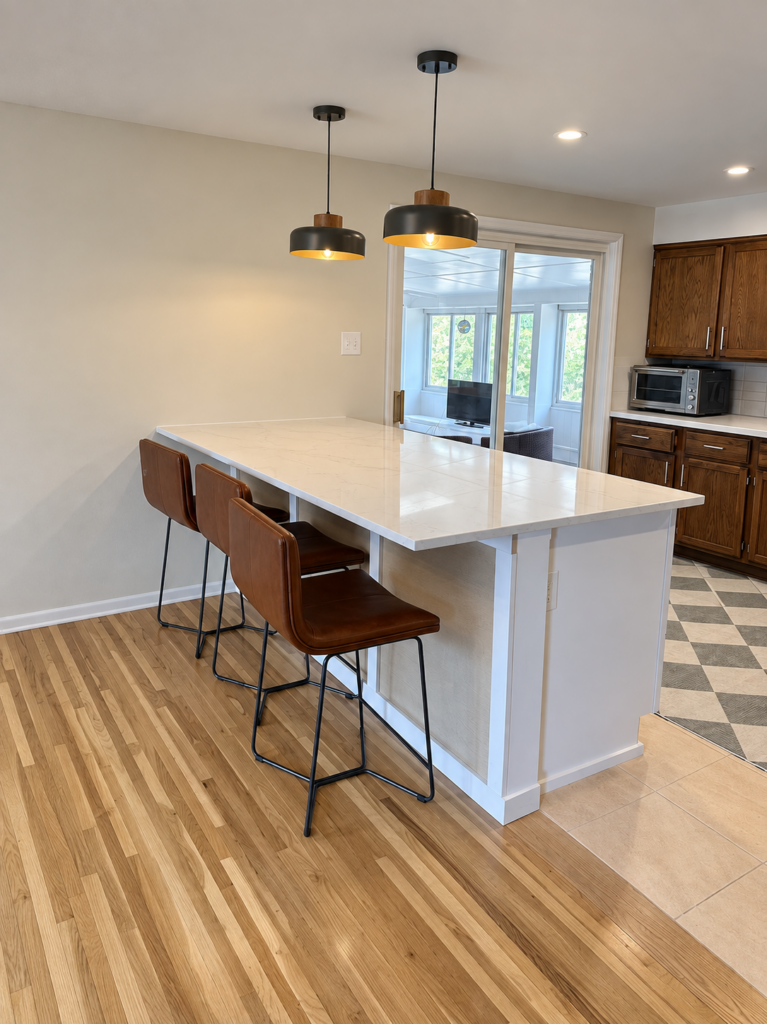 Kitchen island with white quartz waterfall countertop and breakfast bar seating