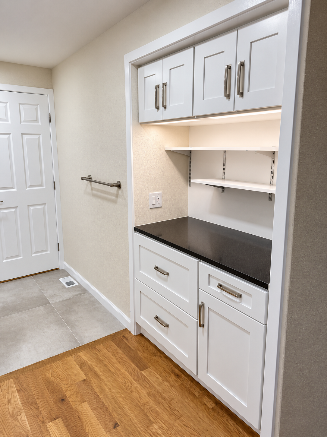 White built-in cabinetry with open shelving and dark countertop, angled view