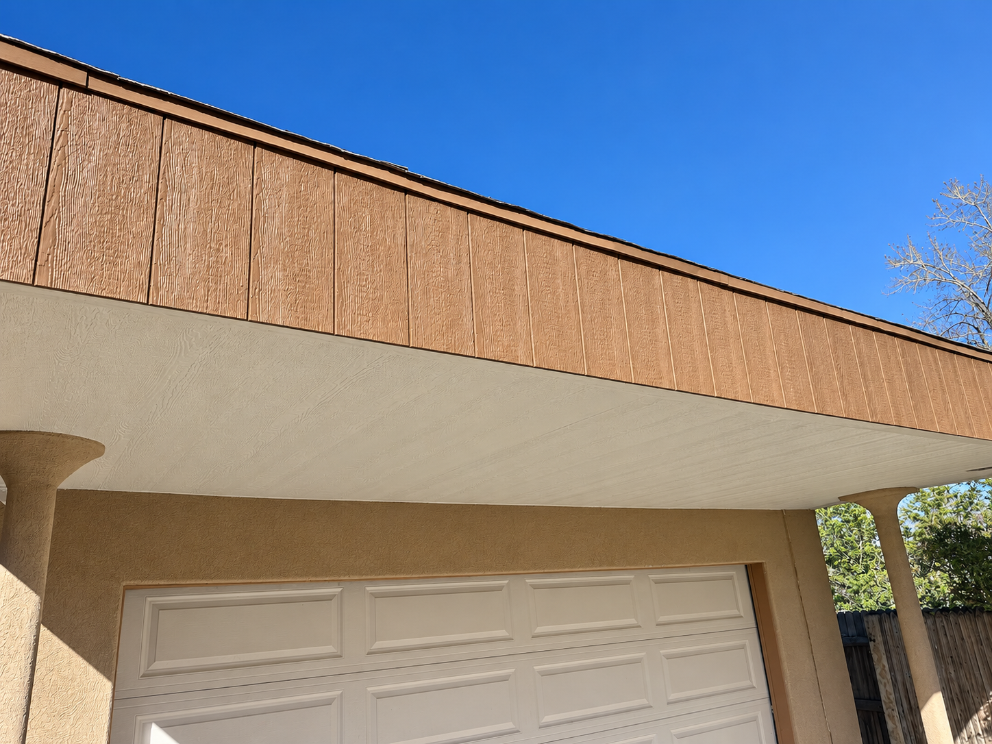 New wood-look fascia and soffit above a garage exterior