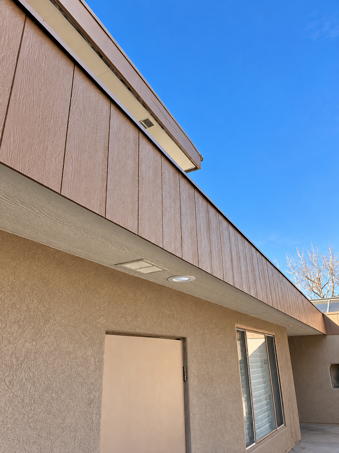 New wood-look fascia and soffit along a patio roofline