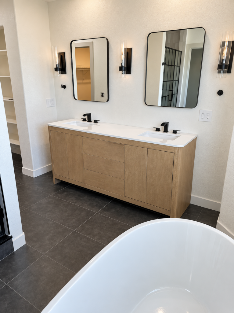 Bathroom with wood vanity, black fixtures, and freestanding tub, front view