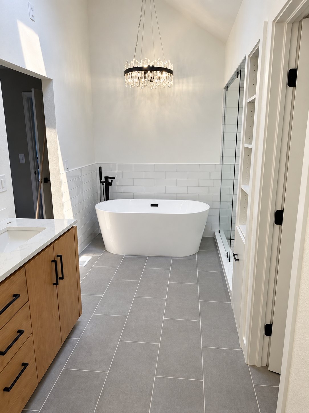 Bathroom with freestanding tub, crystal chandelier, and walk-in shower