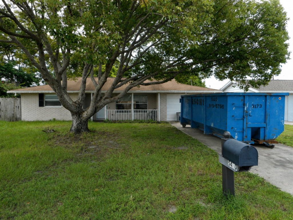 Small ranch home with dumpster in the driveway