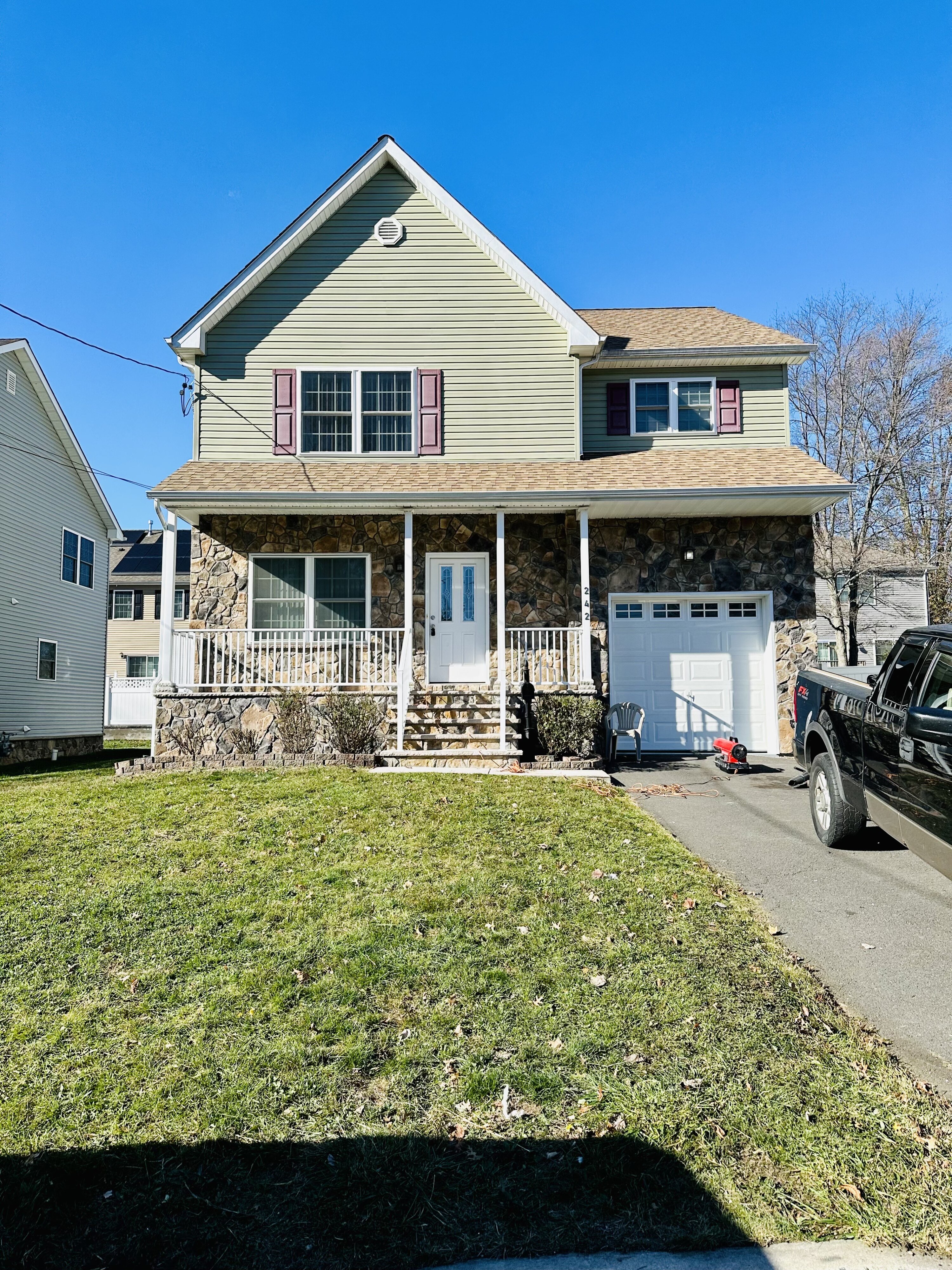 Two-story New Jersey home with a stone front and driveway