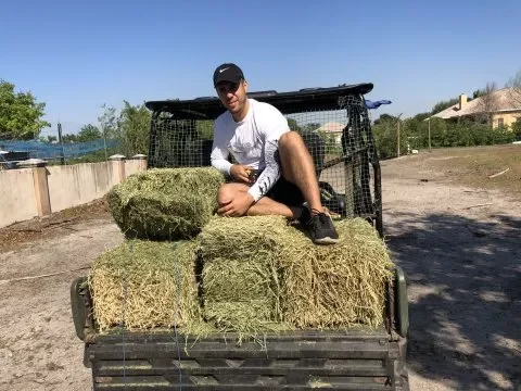 texas home buyer team member on bale of hay
