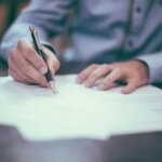 Signing the paperwork to sell a house by owner in Michigan