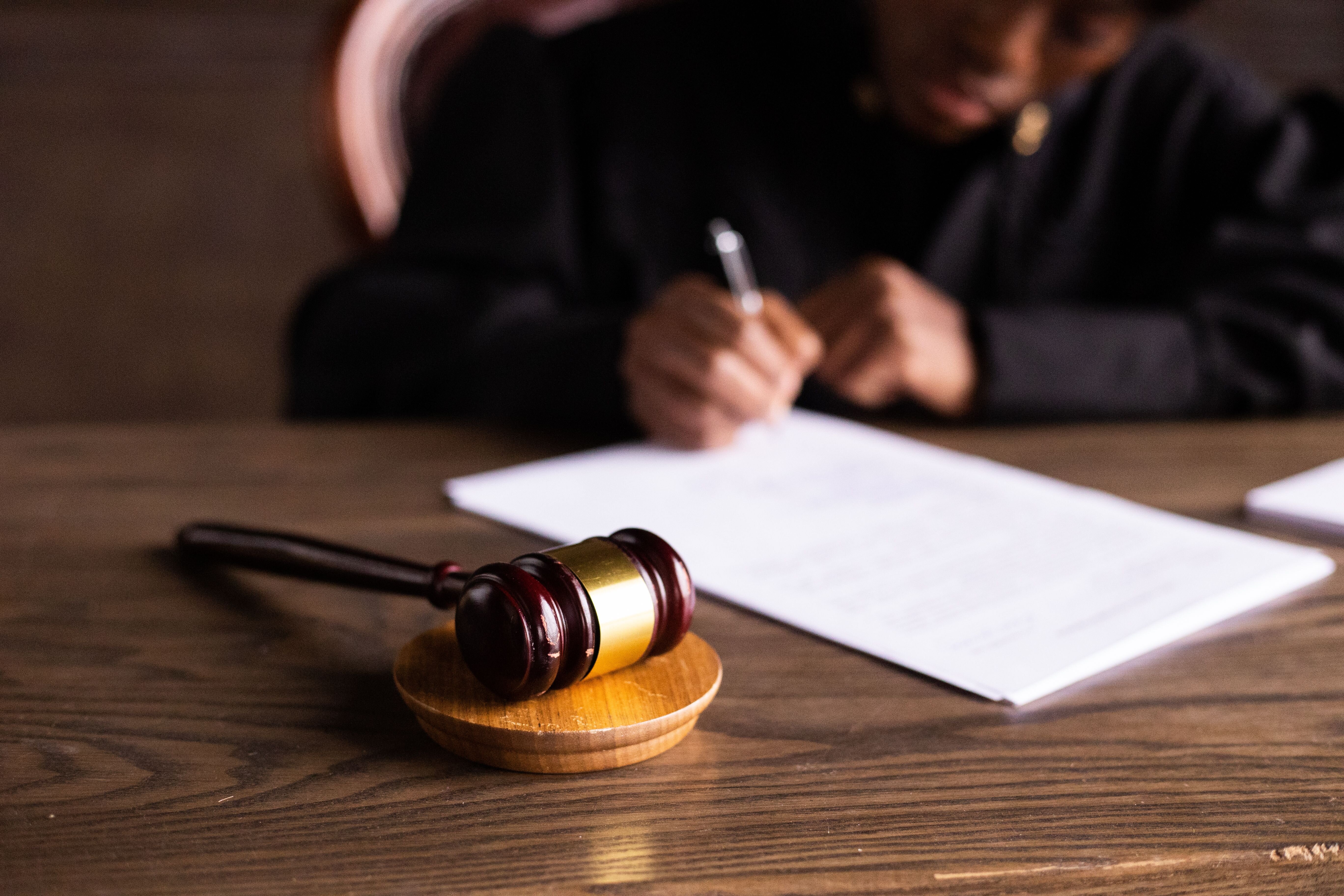 Gavel resting beside a small house model, symbolizing a property auction