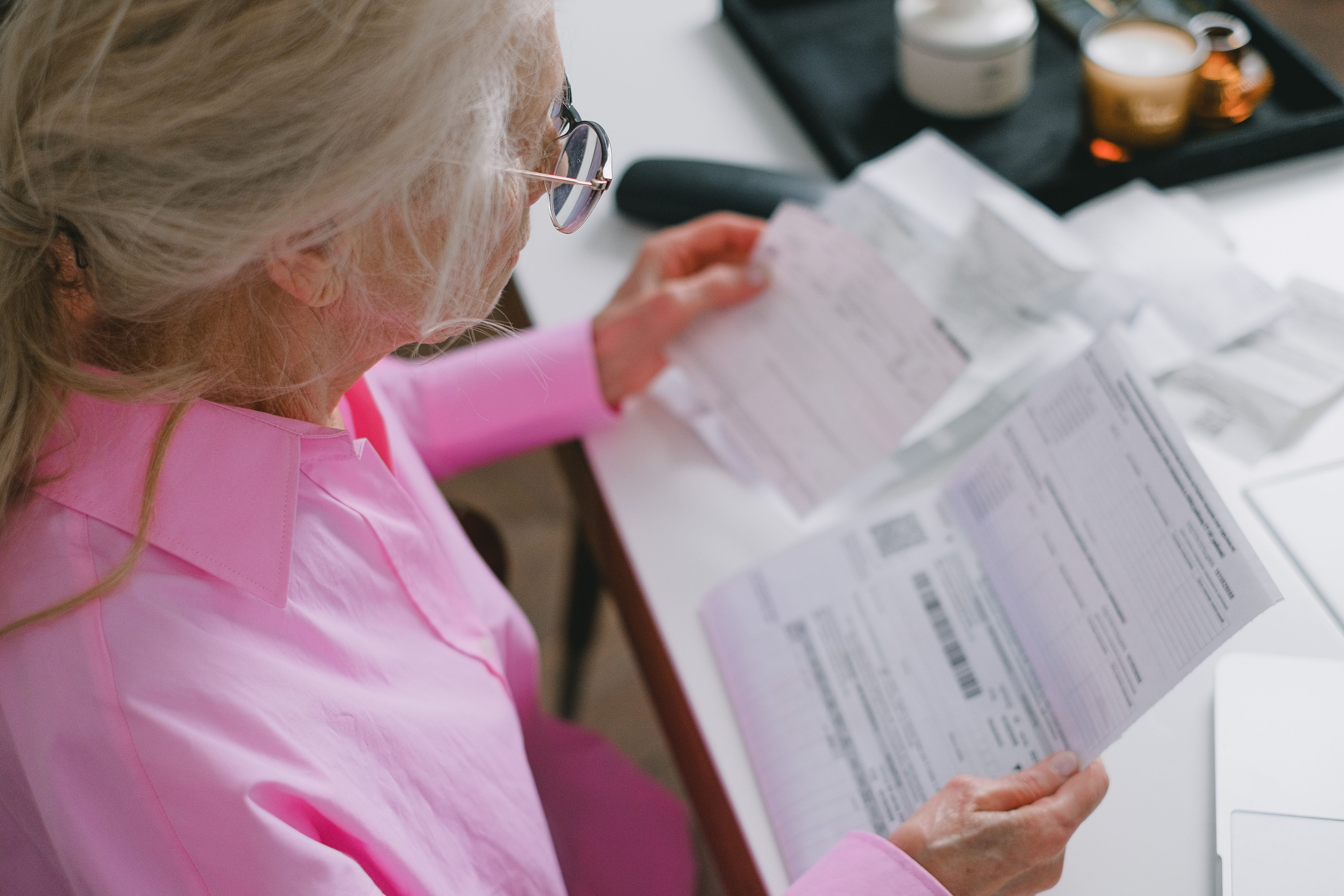 Person reviewing bills and financial paperwork at a table