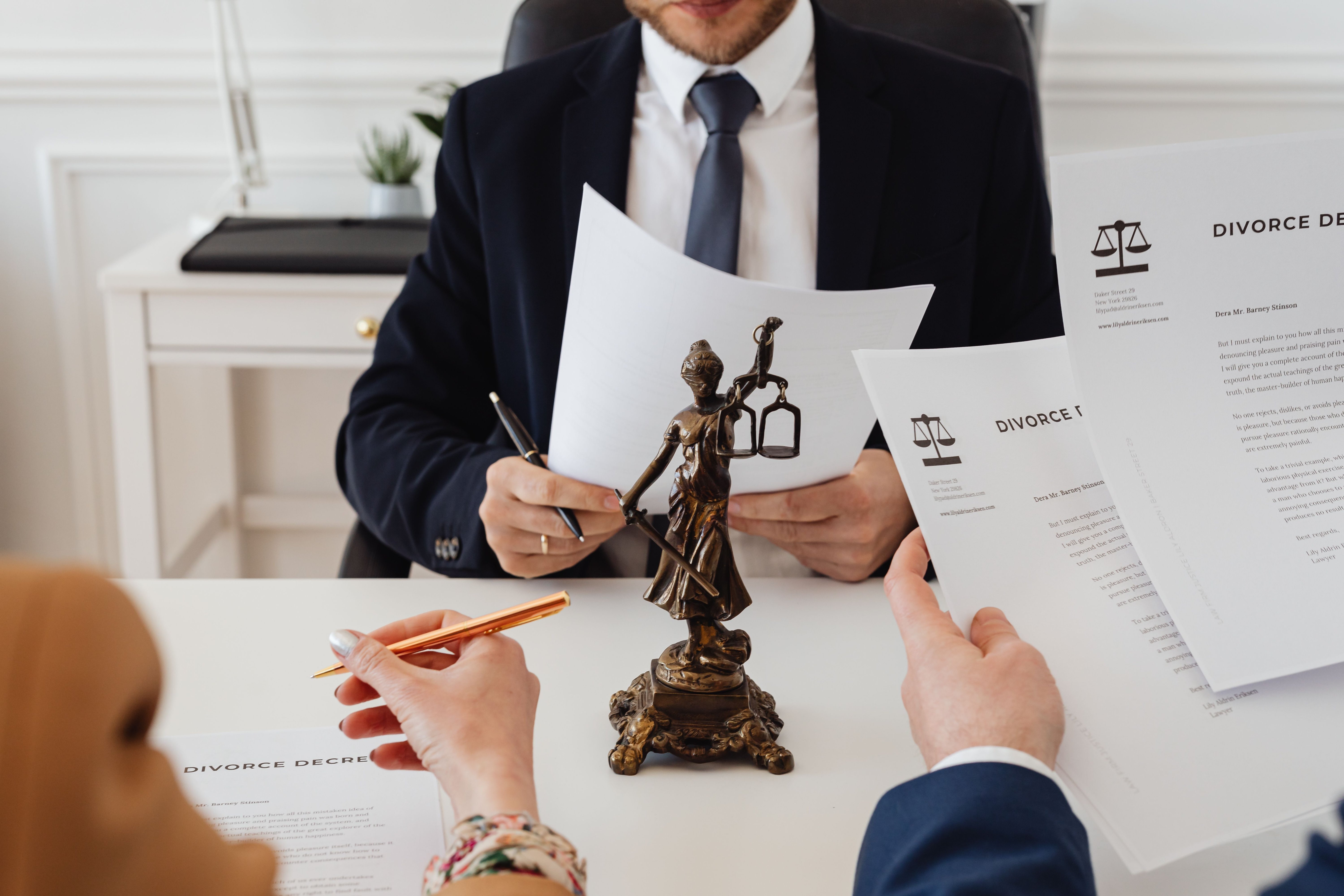 A couple reviewing a written settlement agreement with a pen, representing what to include when the divorce agreement covers selling the house