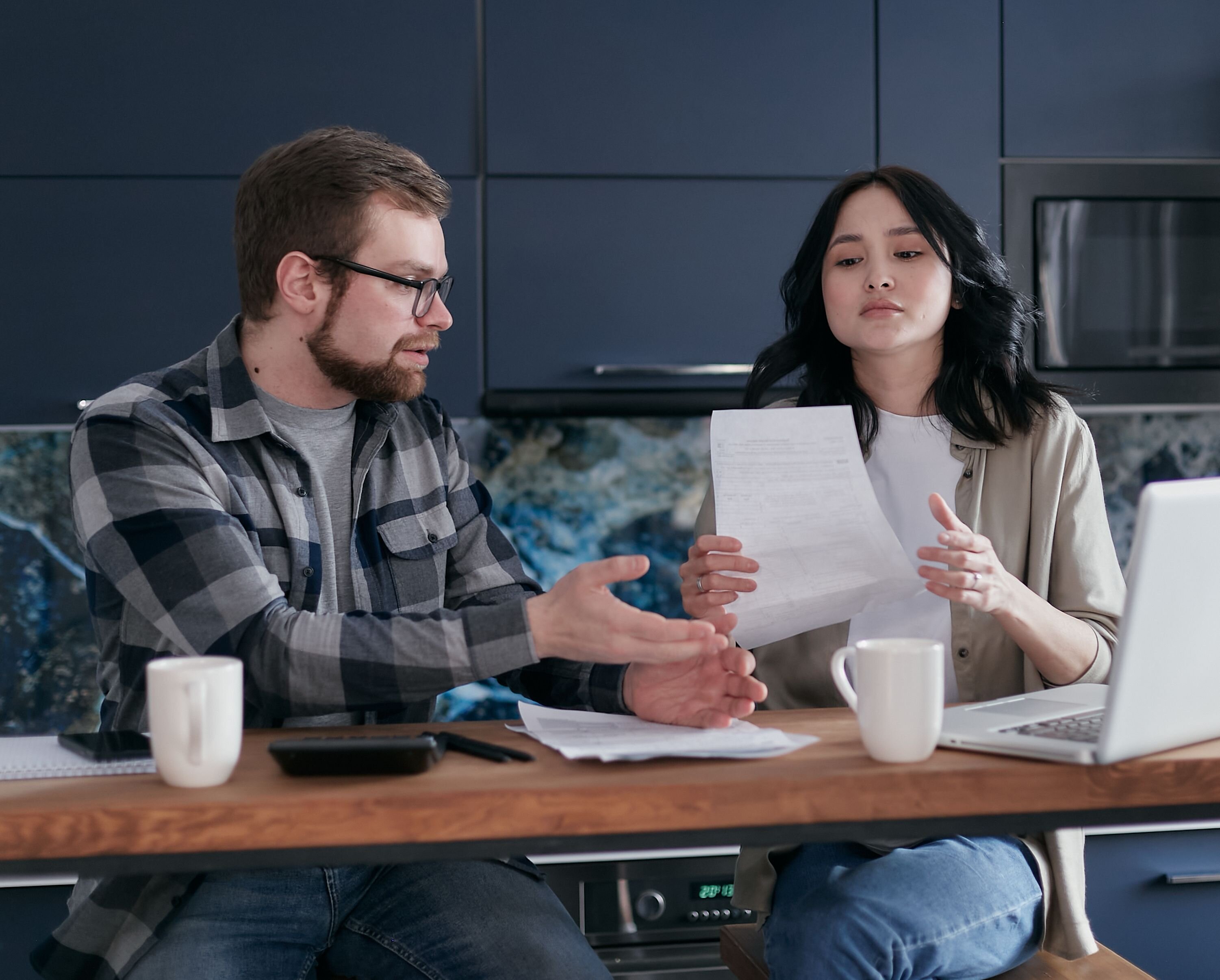 A couple reviewing paperwork at a table, representing a decision about the house during a divorce